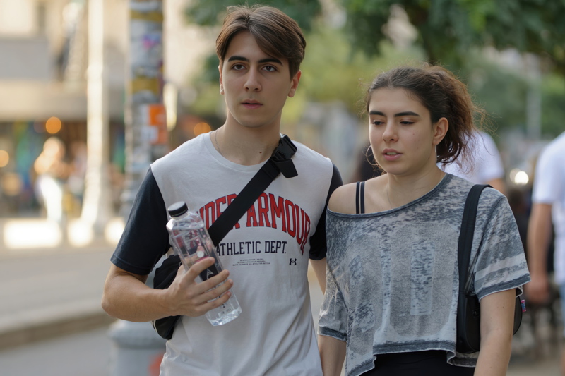 15 - Two individuals walking together on a city street